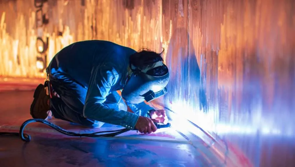 a man wearing a welding mask and holding a welding torch